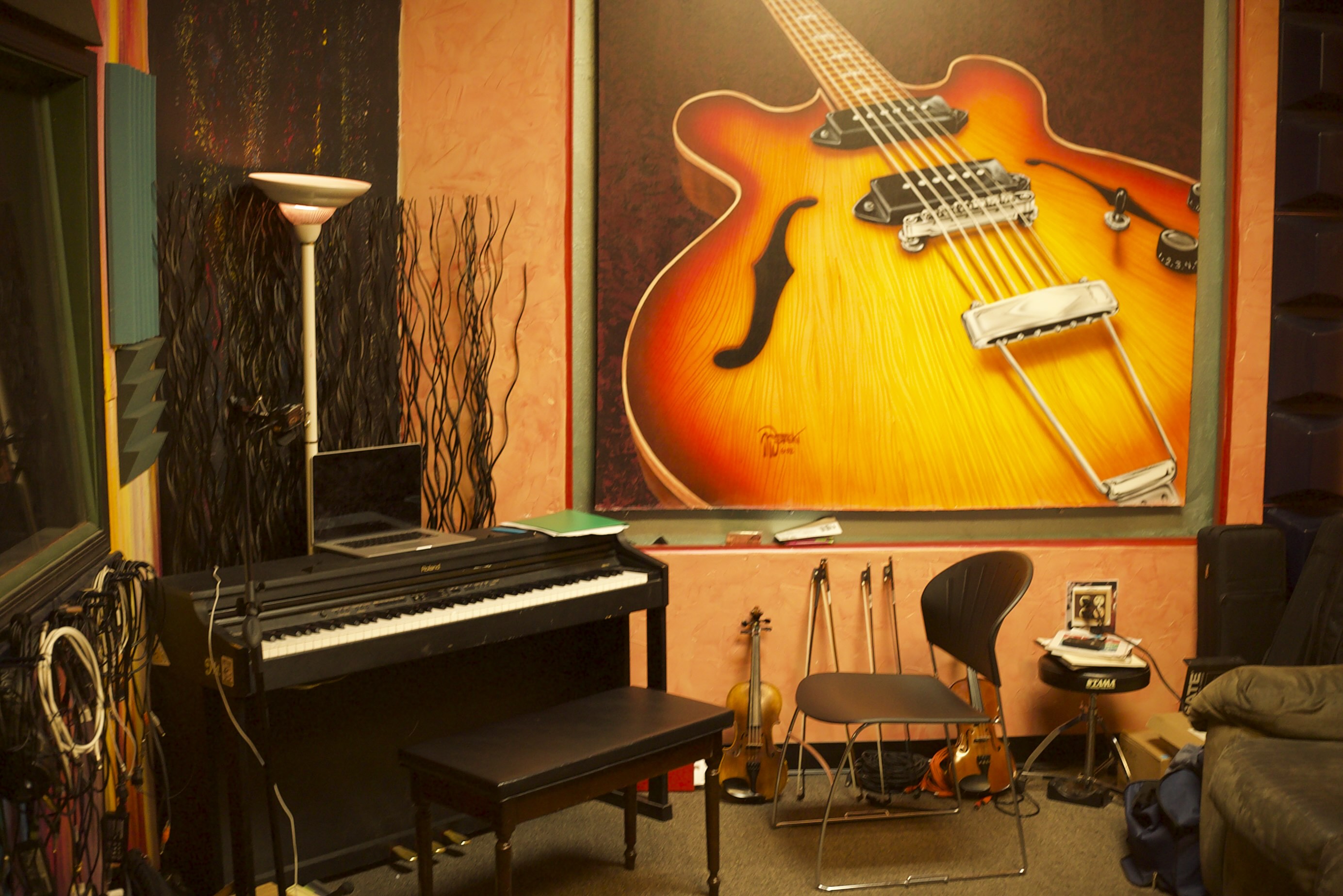 Gavin Hammond piano teaching studio in Albuquerque NM with upright piano and guitar art